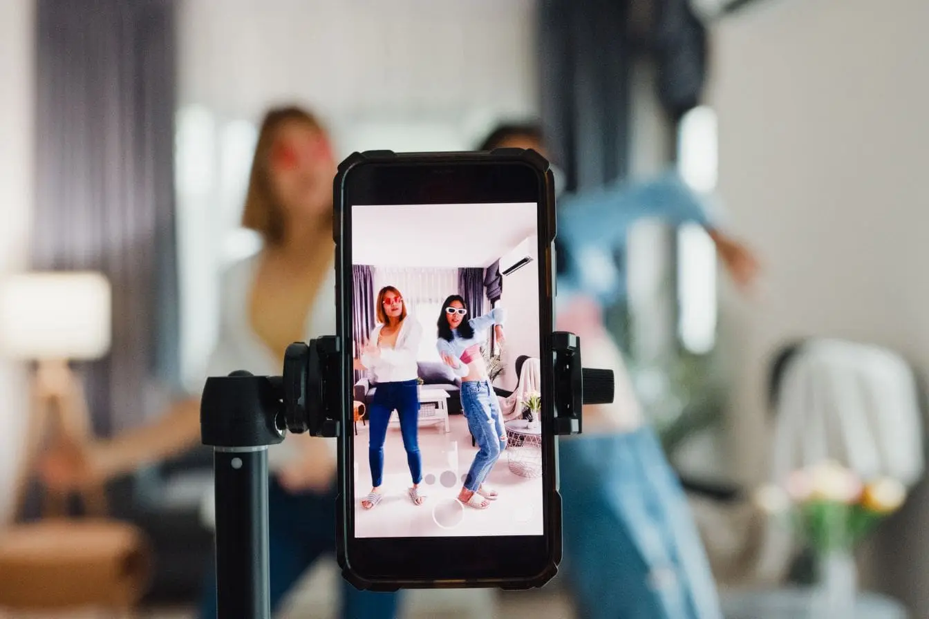 Duo en mouvement devant canapé filmé par téléphone, ambiance reel Instagram prêt à être diffusé sur TikTok