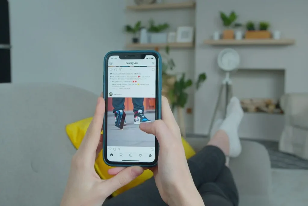 Scène de détente avec smartphone, post Instagram sur des baskets, moment de veille pour optimiser son feed
