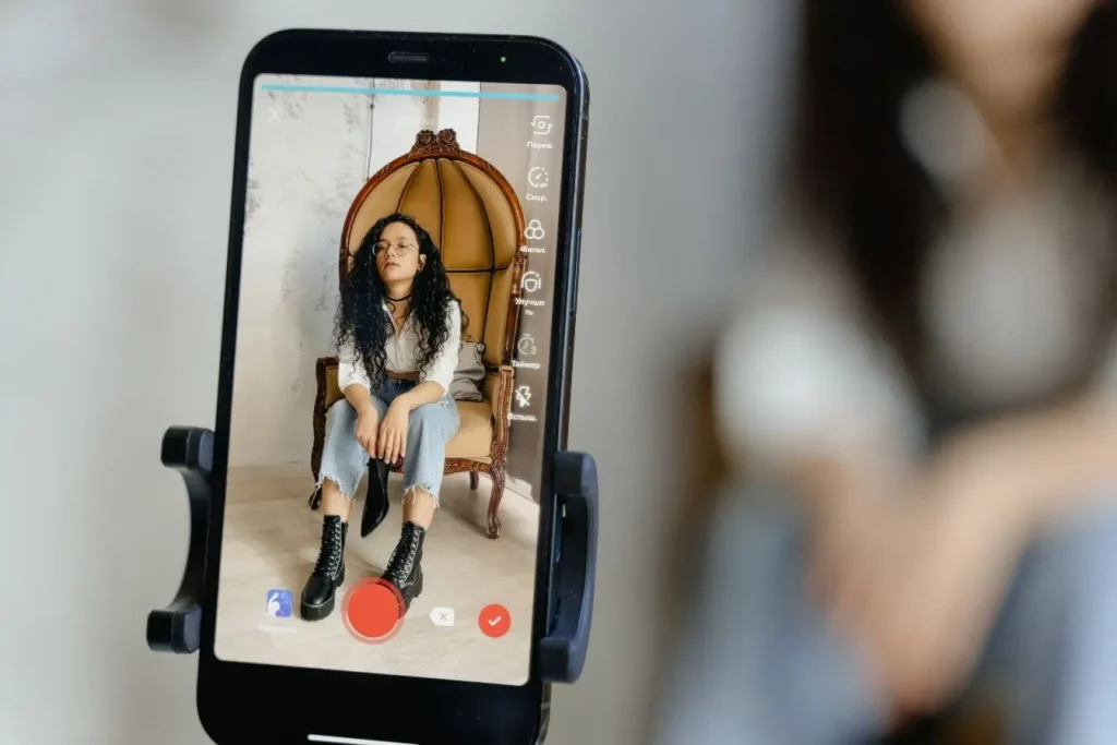 Smartphone filmant une personne assise illustrant la captation optimisée par l’algorithme TikTok