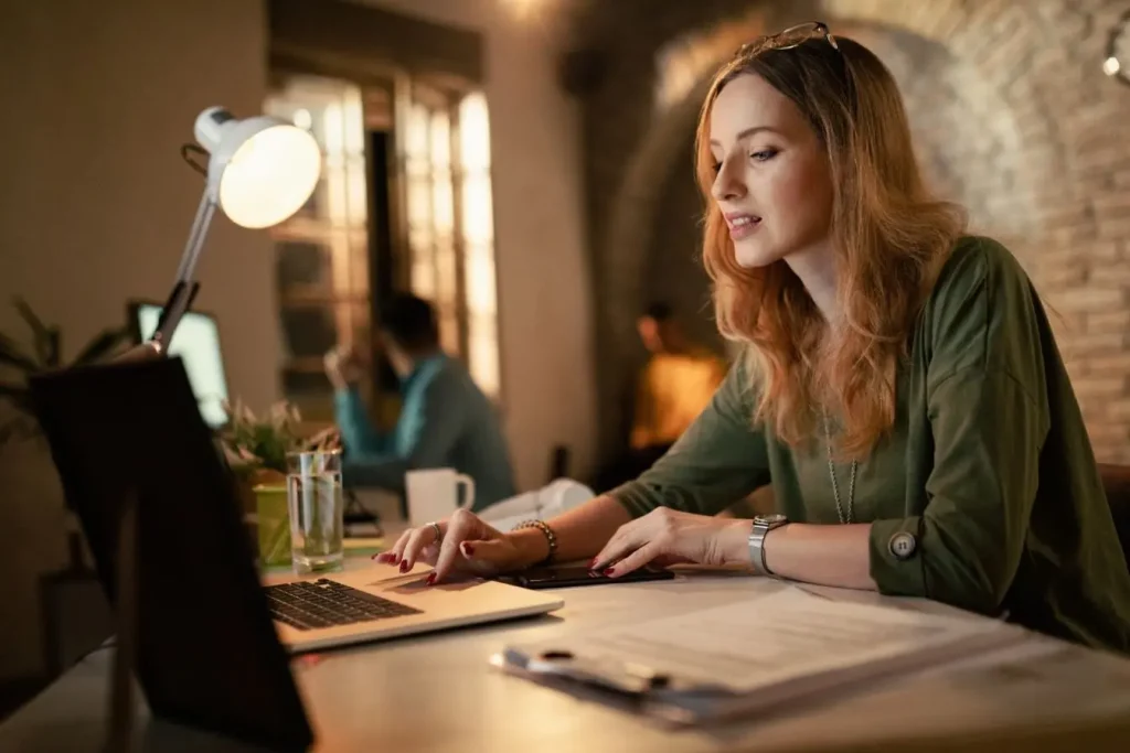 Bureau chaleureux avec personne travaillant sur laptop représentant la production de UGC contenu généré par les utilisateurs.