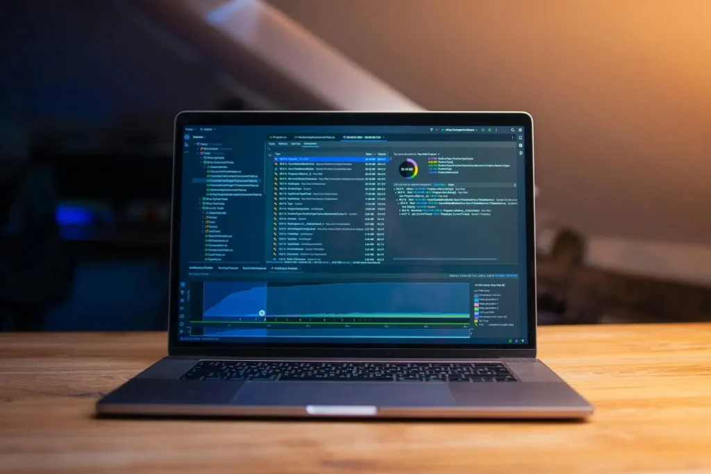 Ordinateur portable affichant interface CRM avec graphiques mémoire et résultats de profilage, illustrant gestion relation client et analyse technique