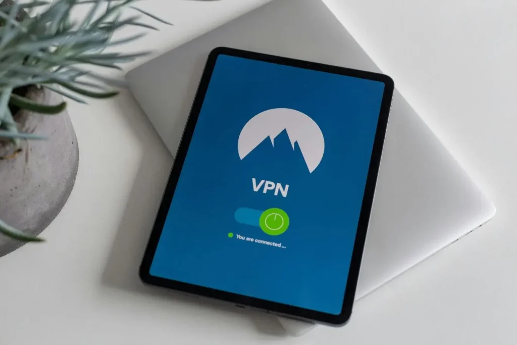 Table avec ordinateur et tablette affichant VPN actif, image illustrant le RGPD et la protection des données personnelles en ligne.