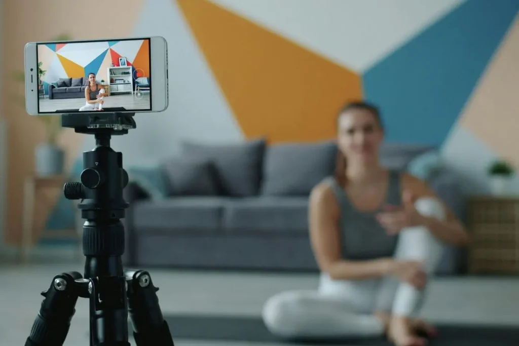 Smartphone sur trépied filmant une personne assise, image illustrant la création de contenu et les opportunités de monétiser un livestream.