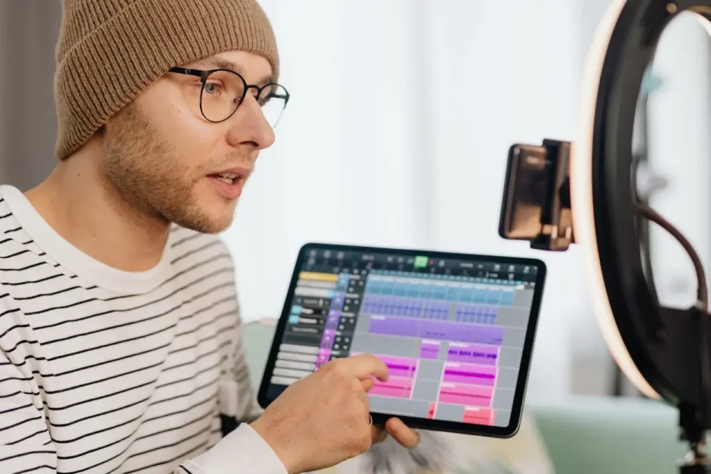 Personne en bonnet montrant écran de production musicale, image d’une stratégie vidéo pour entreprise.