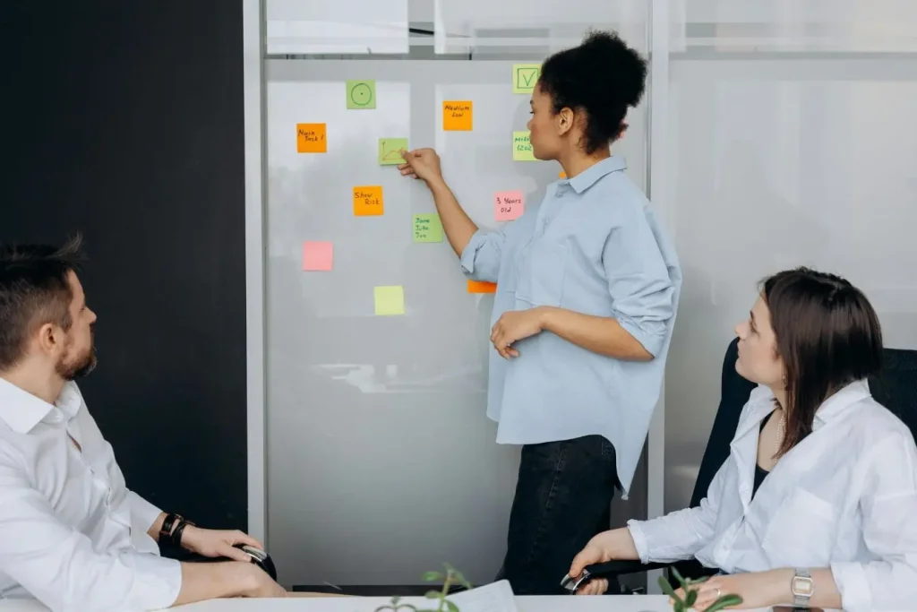 Réunion avec mur couvert de post-it colorés, image illustrant l’Employee Advocacy et la participation active des employés aux idées de l’entreprise.