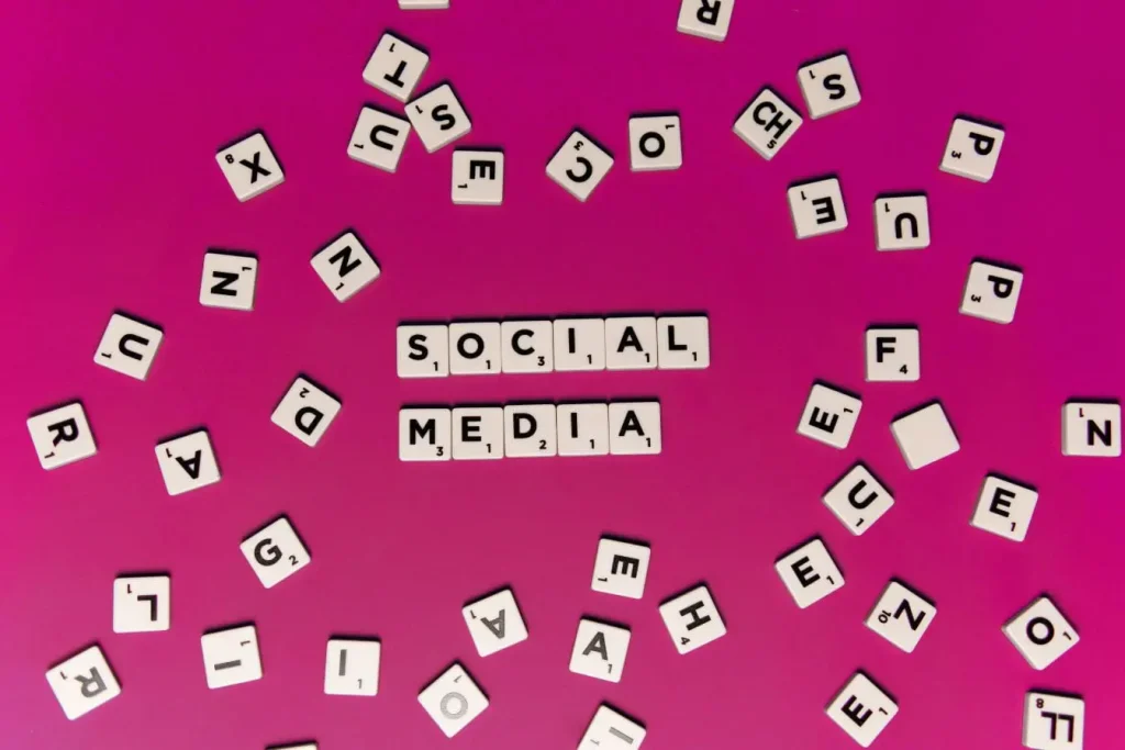 Lettres blanches formant Social Media sur fond rose, image illustrant l’Employee Advocacy et la voix des employés dans la communication digitale.