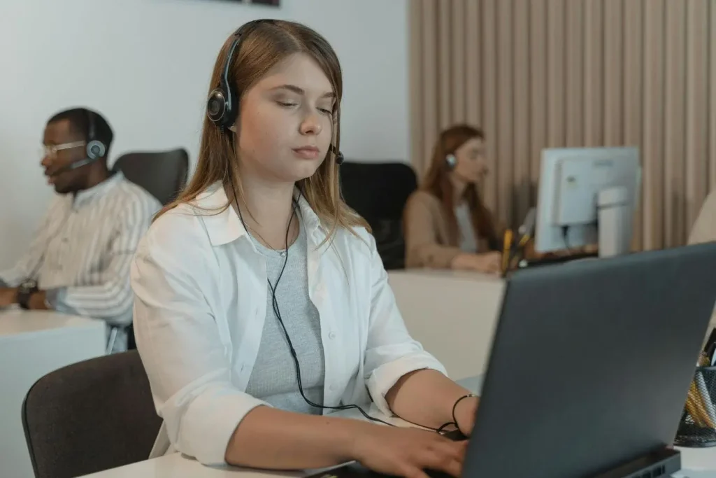 Employés avec casques discutent avec clients en ligne, illustrant un marketing conversationnel centré sur l’écoute et la proximité.