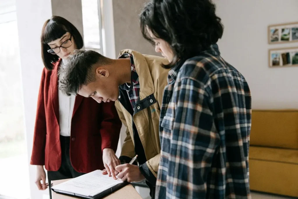 Trois personnes réunies autour d’un document sur clipboard, image illustrant un Term Sheet.