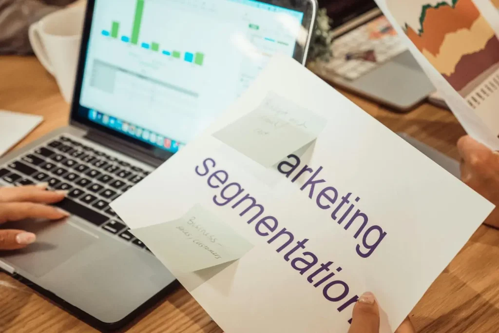 Bureau avec ordinateur affichant graphiques et feuille marketing segmentation, image illustrant l’efficacité du programmatic advertising basé sur données.