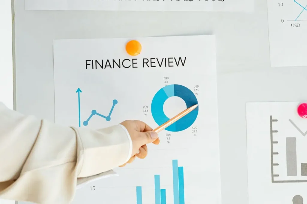 Main pointant un graphique financier sur tableau illustrant la gestion autonome des ressources et l’esprit du bootstrapping.