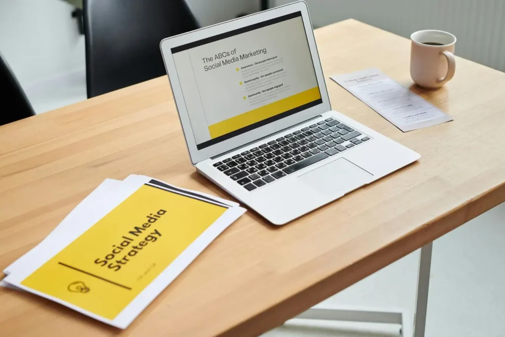 Documents et ordinateur portable sur table, symbole d’un content marketing B2B qui structure stratégie et communication digitale.