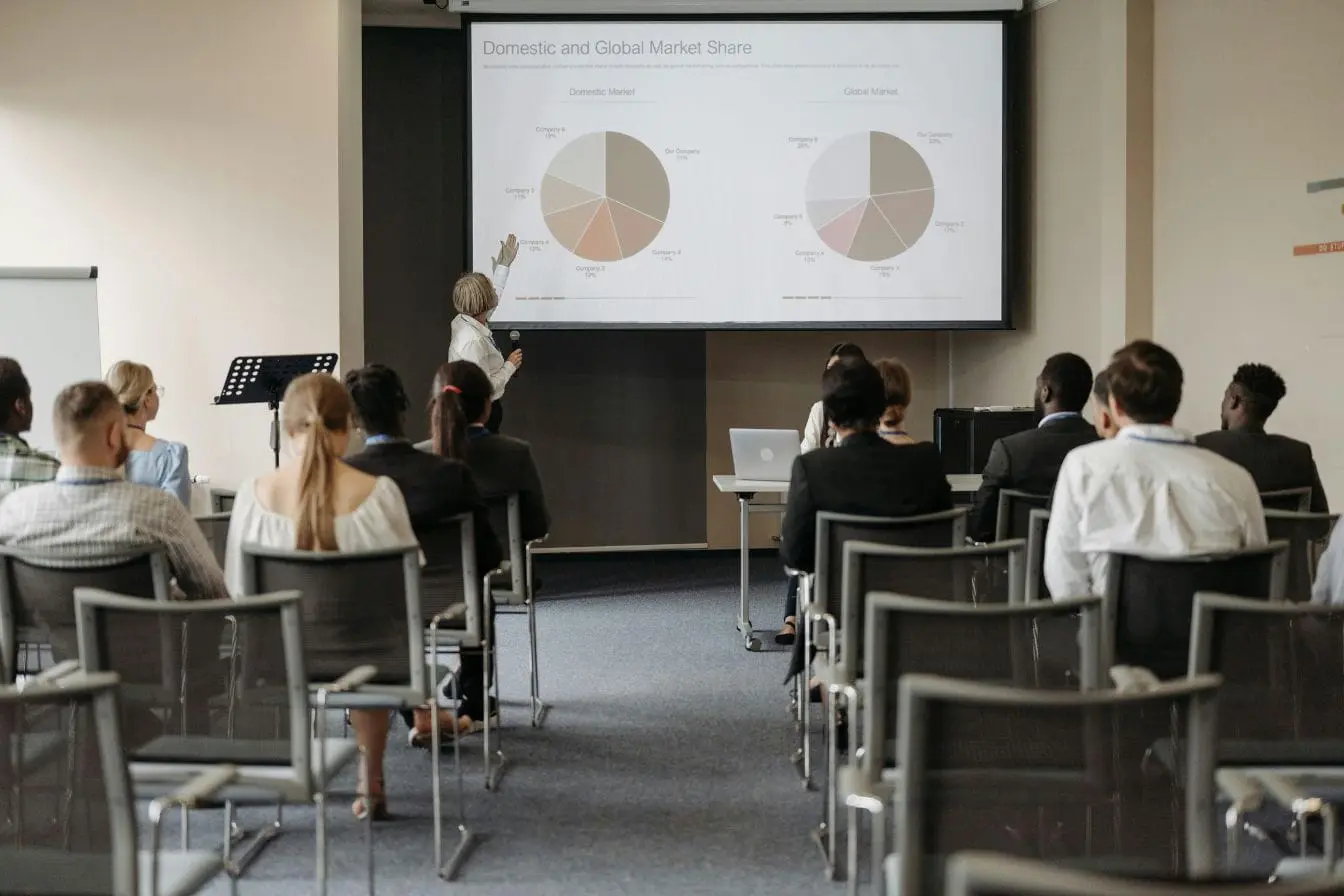 pitch deck Personne présentant diapositives avec graphiques de parts de marché, image illustrant un pitch deck devant investisseurs.