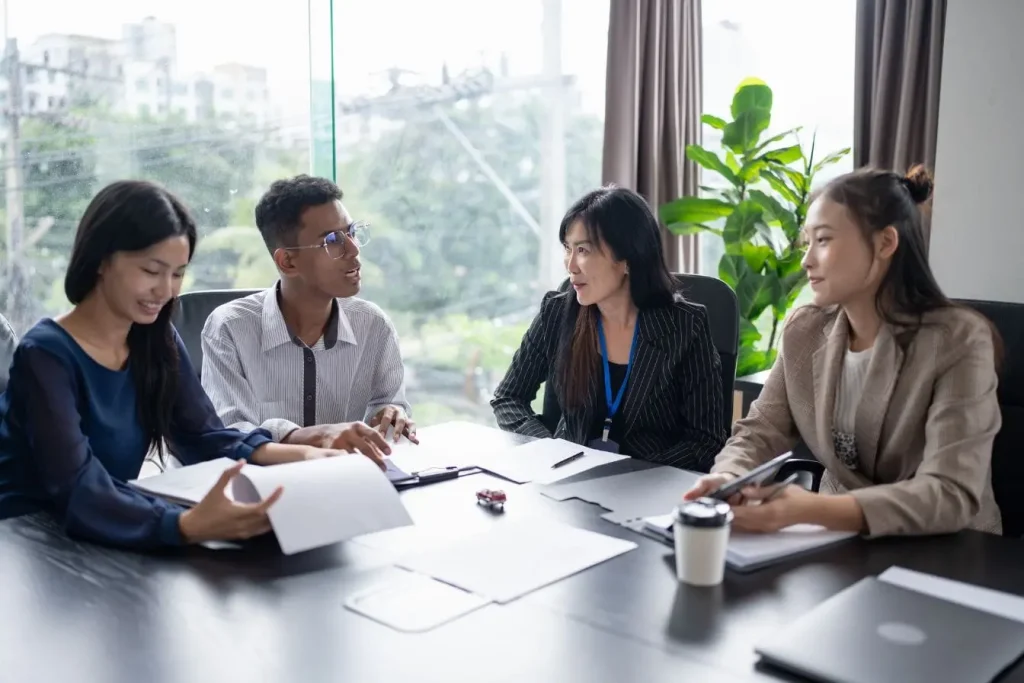 Quatre personnes en réunion reflétant la collaboration et le rôle clé du Customer Success Manager dans la satisfaction client.