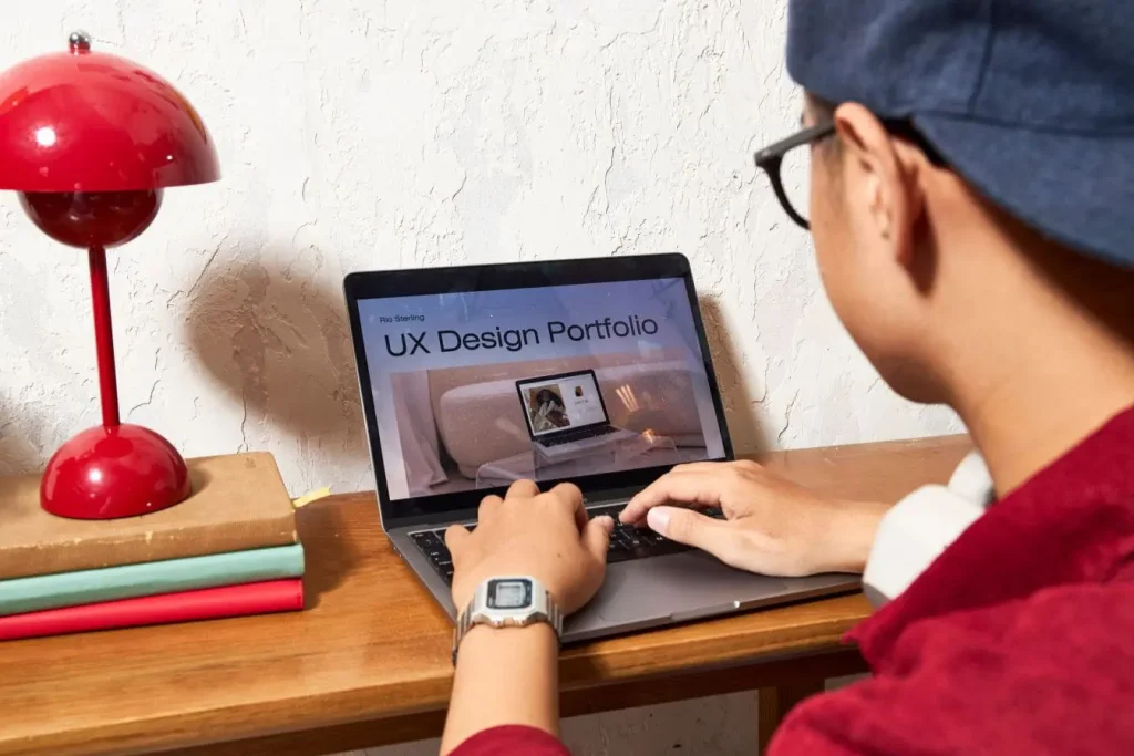 Personne assise devant ordinateur portable affichant portfolio UX, image qui illustre la conception où les Dark Patterns peuvent influencer l’expérience utilisateur.