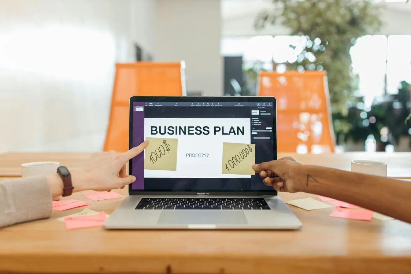 Laptop affiche business plan avec notes de profit, image illustrant la réflexion stratégique entre modèle freemium et premium.