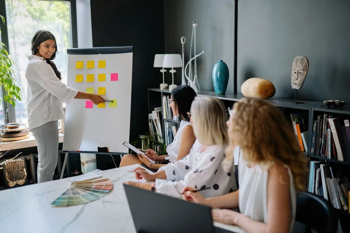 cohorte en marketing Groupe en réunion créative autour d’un tableau rempli de post-it colorés, illustrant une cohorte en marketing en pleine réflexion stratégique.