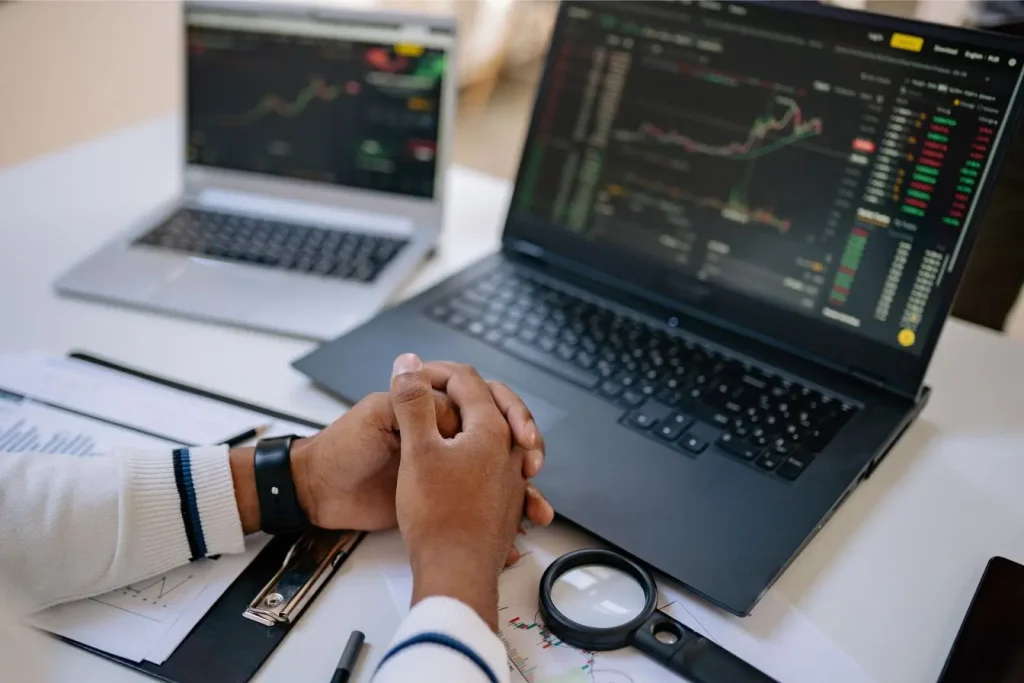 Bureau avec deux ordinateurs affichant graphiques financiers, image qui illustre la réflexion sur les différences entre Data Lake et Data Warehouse.