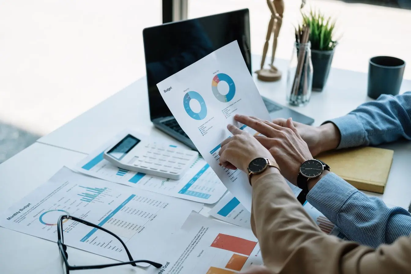 Deux personnes analysant graphiques budgétaires imprimés, image qui illustre la stratégie ciblée de l’Account Based Marketing.