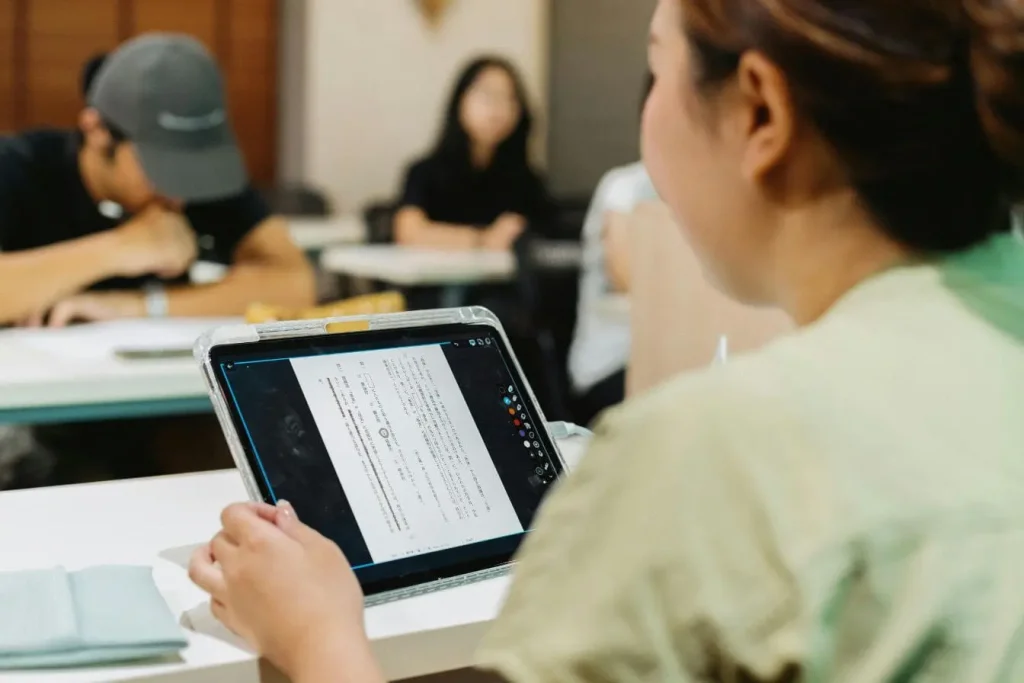 Salle de classe avec tablette affichant texte japonais, image qui illustre l’apprentissage supervisé et non supervisé en machine learning.
