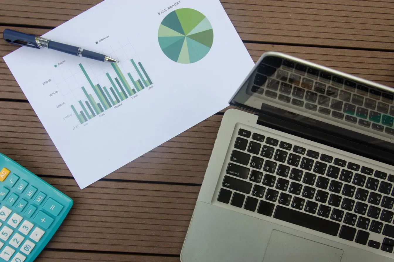 calcul ratio CAC LTV Bureau avec ordinateur, calculatrice et graphiques financiers, reflet du suivi du ratio CAC LTV pour analyser rentabilité client.