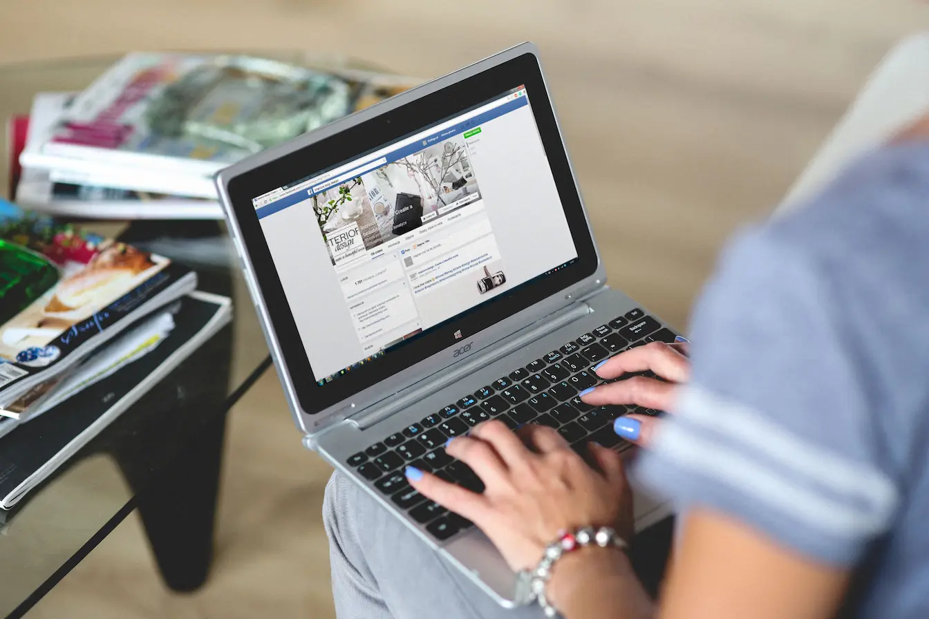réseau social Laptop posé sur genoux avec réseau social affiché, symbole des échanges cachés du Dark Social.