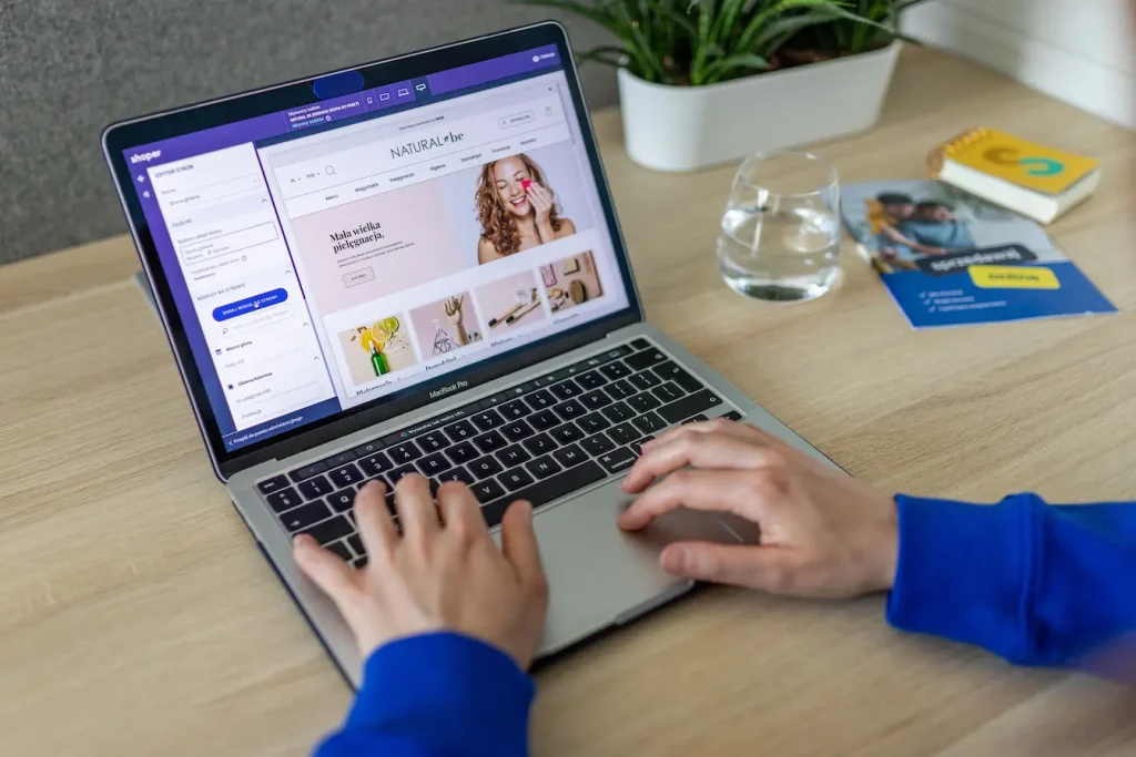 Personne travaillant sur MacBook avec éditeur de site ouvert, image qui illustre l’importance du certificat SSL pour sécuriser un site web.