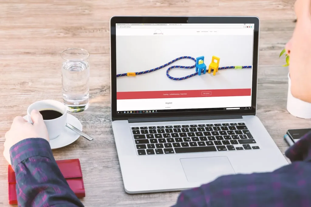 Personne assise devant laptop affichant site de coaching, image qui illustre la différence entre cookies first‑party et third‑party.