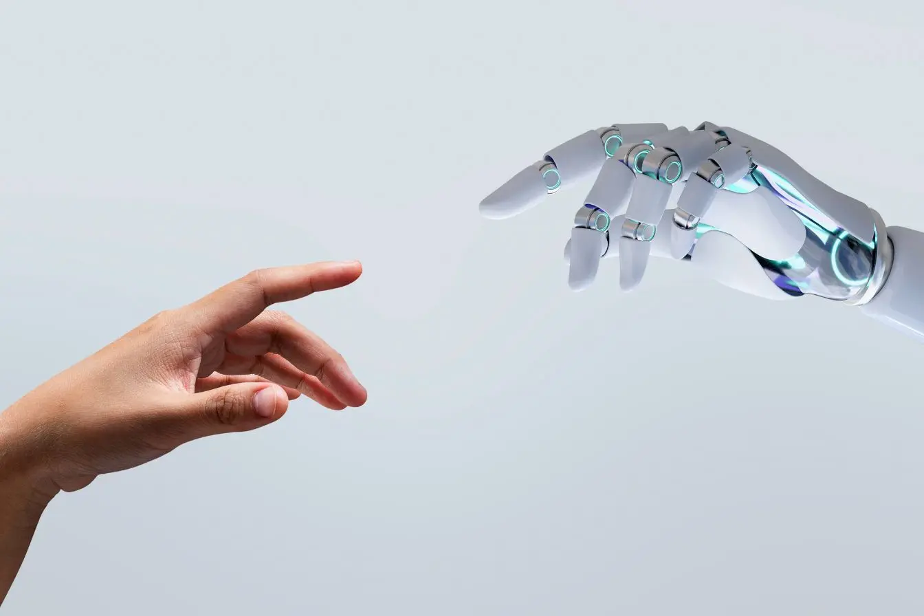 Main humaine tendue vers une main robotisée dans un environnement épuré, illustrant le fine-tuning d’un modèle d’IA pour mieux répondre à des besoins spécifiques