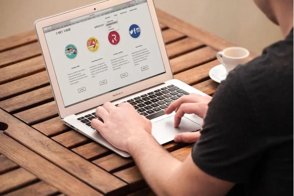 Un développeur écrit du code pour automatiser l'Infrastructure as Code (IaC) sur son ordinateur portable en télétravail près d'une tasse de café.
