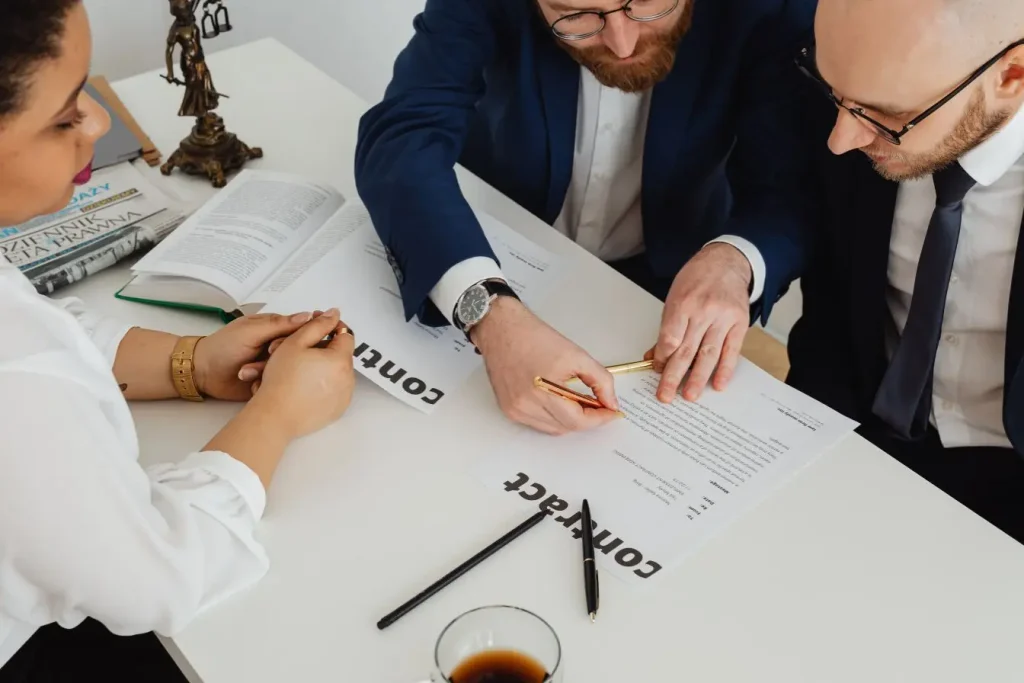 Professionnels réunis autour d’un contrat commercial pour étudier les conditions d’adhésion à une franchise commerciale et son modèle de développement