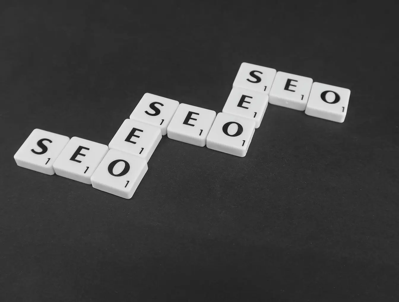 Tuiles blanches disposées en motif SEO, symbole d’une stratégie de contenu pilier pour renforcer visibilité en ligne.